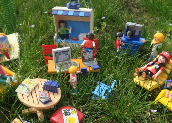 playmobils dans l'herbe en train de lire, écouter de la musique...