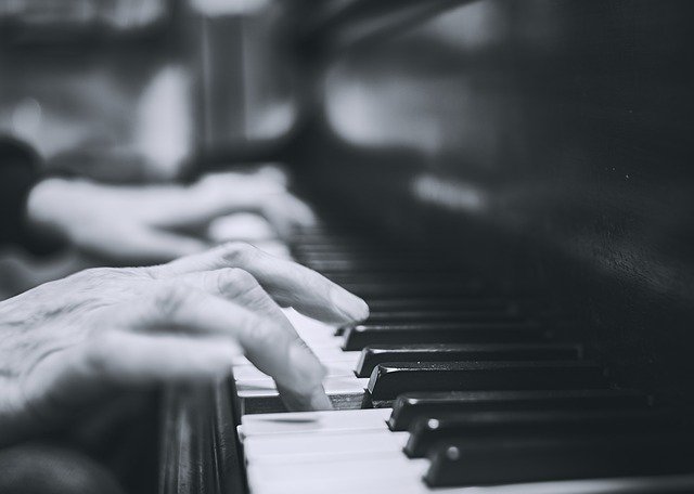mains jouant sur un clavier de piano