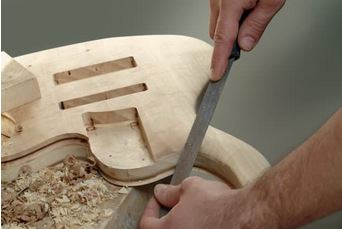 mains de luthier travaillant le bois